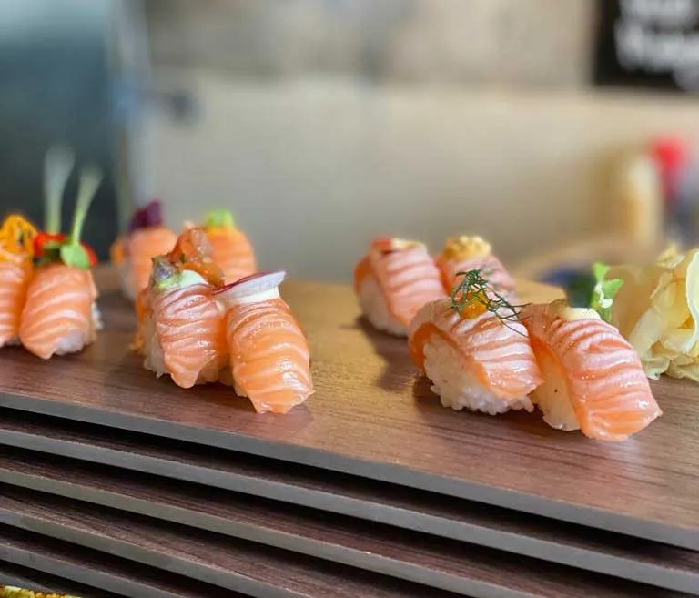 Färsk sushi upplagd på en traditionell japansk träplanka